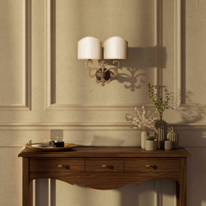 Neoclassical twin brass wall lamp with fleur-de-lis motif and symmetrical scrolls, white pleated shades, elegant Italian design - Finish: OAS Antique Brass