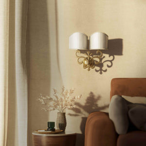 Neoclassical twin brass wall lamp with fleur-de-lis motif and symmetrical scrolls, white pleated shades, elegant Italian design - Finish: OBS Bronze Satin Brass
