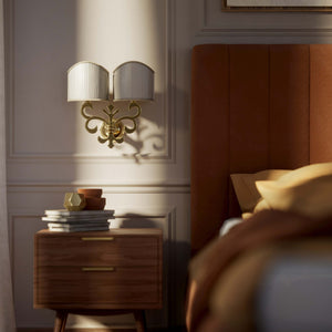 Neoclassical twin brass wall lamp with fleur-de-lis motif and symmetrical scrolls, white pleated shades, elegant Italian design - Finish: OLV Polished Brass