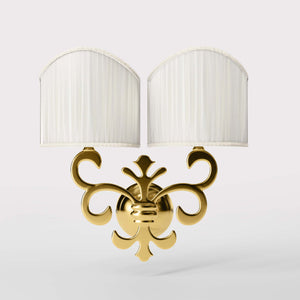 Neoclassical twin brass wall lamp with fleur-de-lis motif and symmetrical scrolls, white pleated shades, elegant Italian design - Finish: ORO 24K Gold Plated