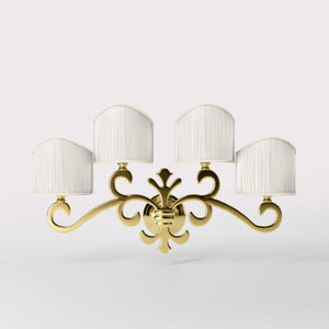Classical four-light brass wall lamp with central fleur-de-lis and decorative scrolls, white pleated shades, refined Italian design - Finish: OLV Polished Brass