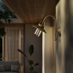 Outdoor brass wall lamp with curved arm protective hood and transparent glass diffuser rustic style Giada collection by Ghidini 1849 - Finish: OAS Antique Brass