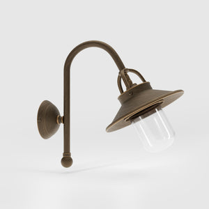 Outdoor brass wall lamp with curved arm protective hood and transparent glass diffuser rustic style Giada collection by Ghidini 1849 - Finish: OBM Bronze Satin Matt Brass