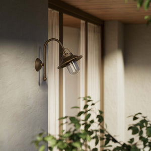 Outdoor brass wall lamp with curved arm protective hood and transparent glass diffuser rustic style Giada collection by Ghidini 1849 - Finish: OBM Bronze Satin Matt Brass