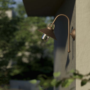 Country style outdoor brass wall lamp with arched arm protective hood and transparent glass diffuser Giada collection by Ghidini 1849 - Finish: OBM Bronze Satin Matt Brass