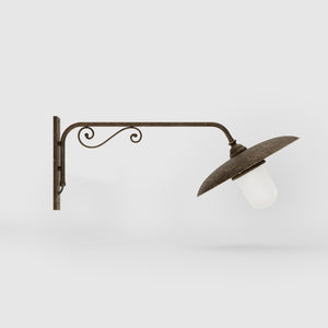 Brass outdoor wall lamp with decorative arm and protected glass by Ghidini 1849 - Finish: OAS Antique Brass