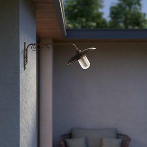 Brass outdoor wall lamp with decorative arm and protected glass by Ghidini 1849 - Finish: OAS Antique Brass