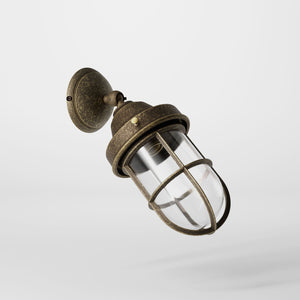Rustic outdoor wall light in brass with clear glass shade, industrial maritime design, and adjustable joint by Ghidini 1849 - Finish: OAS Antique Brass