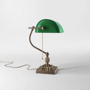 Banker’s lamp in brass with green glass shade, decorative base, and pull-chain switch. Elegant desk or decorative lighting by Ghidini 1849 - Finish: OAS Antique Brass