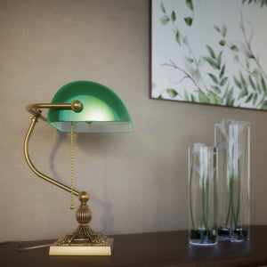 Banker’s lamp in brass with green glass shade, decorative base, and pull-chain switch. Elegant desk or decorative lighting by Ghidini 1849 - Finish: OBS Bronze Satin Brass