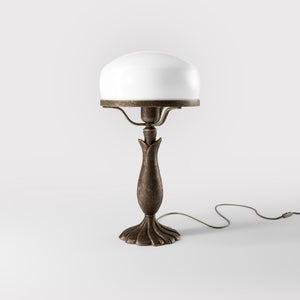 Art Deco table lamp with glossy white mushroom glass shade, sculpted brass base with undulating motifs, Italian design by Ghidini 1849 - Finish: OAS Antique Brass