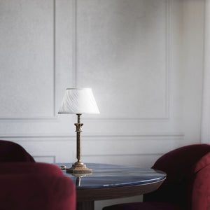 Classic brass table lamp with an ivory fabric shade, featuring an ornate column base, ideal for living rooms or office spaces by Ghidini 1849 - Finish: OAS Antique Brass