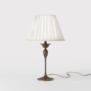 Art Nouveau table lamp Simona collection with decorated brass base featuring floral motifs and pleated ivory white fabric lampshade by Ghidini 1849 - Finish: OAS Antique Brass
