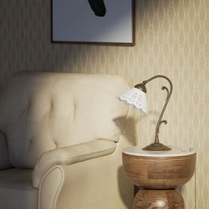 Art Nouveau table lamp with white pierced ceramic shade and decorative curved adjustable brass arm structure by Ghidini 1849 - Finish: OAS Antique Brass