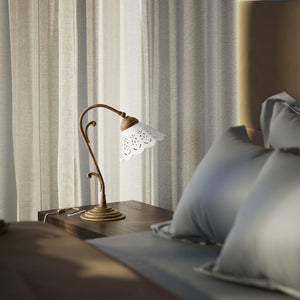 Art Nouveau table lamp with white pierced ceramic shade and decorative curved adjustable brass arm structure by Ghidini 1849 - Finish: OAS Antique Brass