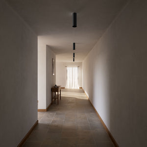 Cylindrical ceiling lamp in brass Venere installed in a contemporary hallway interior by Ghidini 1849 - Finish: ONO Matt Black
