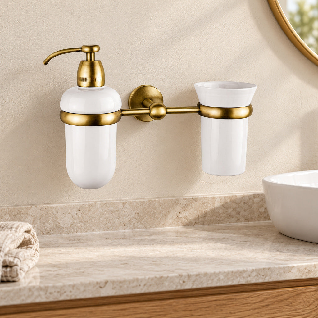 Adele wall-mounted brass dispenser and white ceramic tumbler beside a bathroom basin.