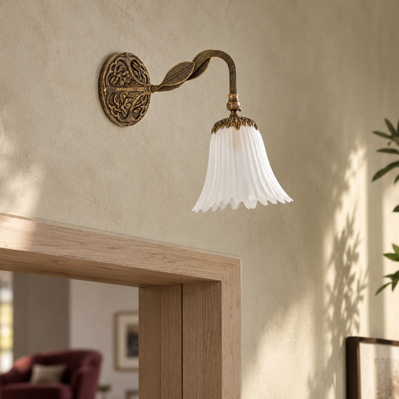 Applique Dalida in ottone anticato con campana in vetro bianco dal bordo ondulato in un salotto contemporaneo.