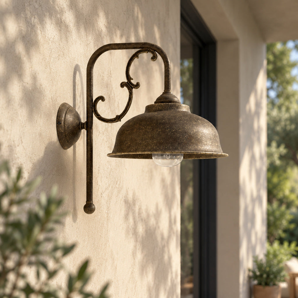 Lipari Wandleuchte aus antikem Messing neben einem dunklen Fenster am Gartenportikus.