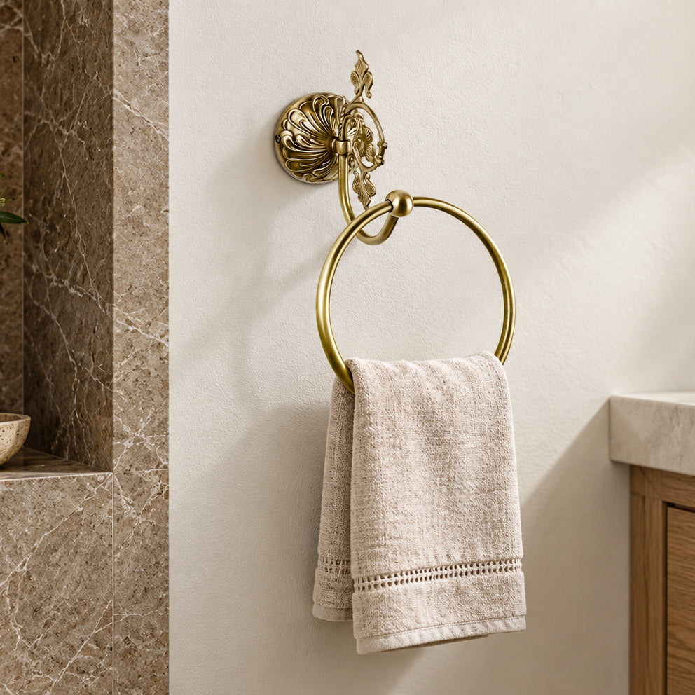 Penelope brass towel ring with leaf decoration and a linen hand towel.