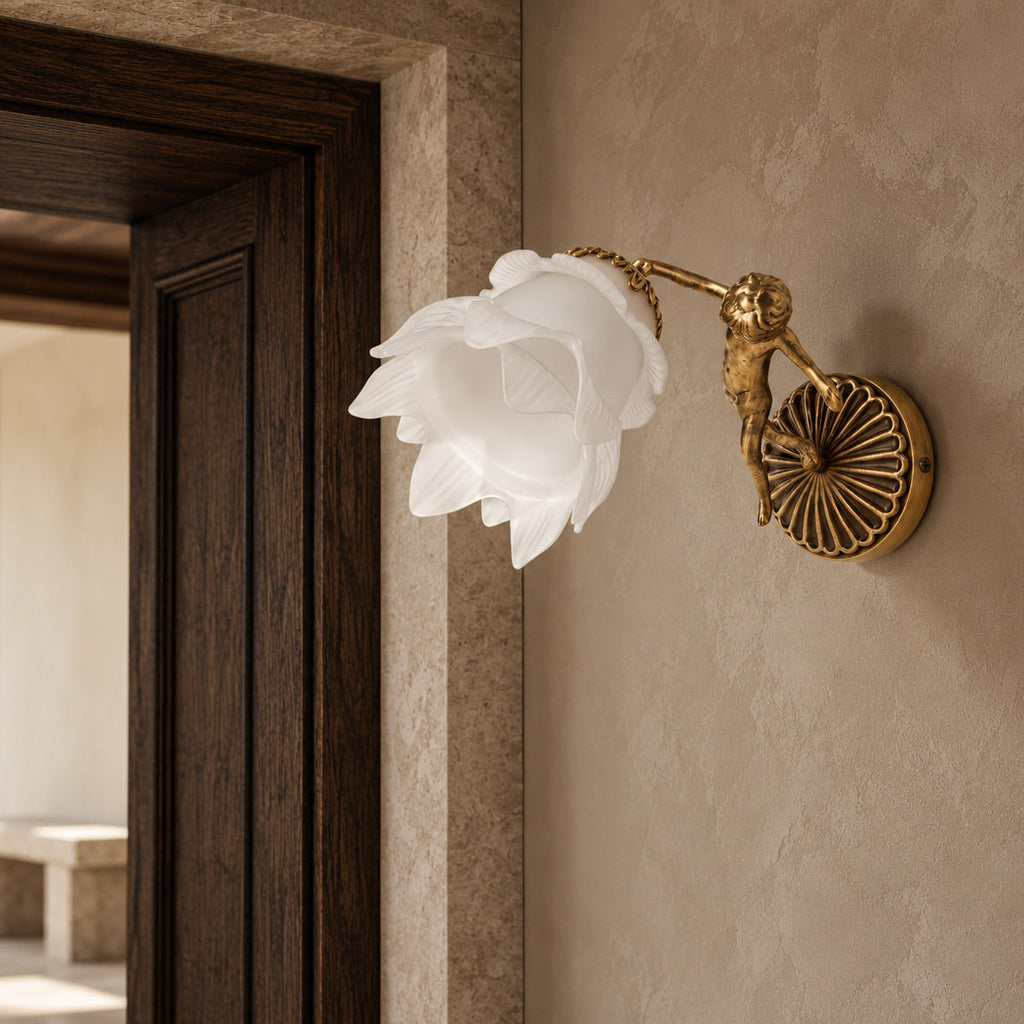 Putti wall lamp with a decorative brass cherub and white flower glass beside an oak and stone doorway.