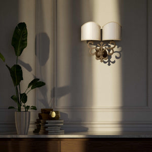 Neoclassical twin brass wall lamp with fleur-de-lis motif and symmetrical scrolls, white pleated shades, elegant Italian design - Finish: OAS Antique Brass