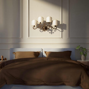 Classical four-light brass wall lamp with central fleur-de-lis and decorative scrolls, white pleated shades, refined Italian design - Finish: OAS Antique Brass