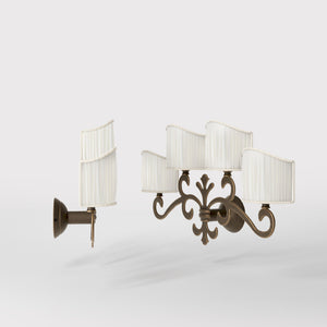 Classical four-light brass wall lamp with central fleur-de-lis and decorative scrolls, white pleated shades, refined Italian design - Finish: OBM Bronze Satin Matt Brass