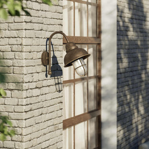 Outdoor industrial wall lamp Chronos with brass structure, bell-shaped diffuser and protective transparent glass cage for exterior lighting by Ghidini 1849 - Finish: OAS Antique Brass