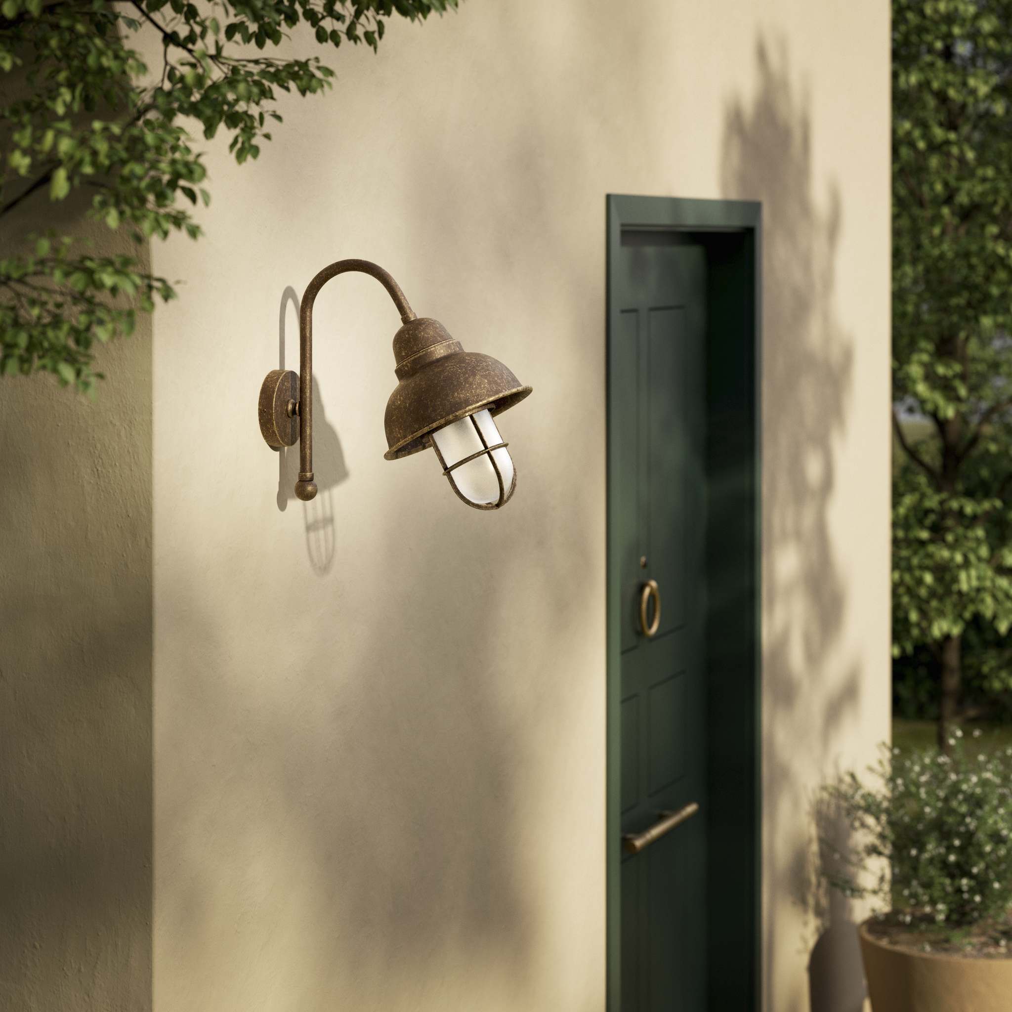 Outdoor industrial wall lamp Chronos with brass structure, bell-shaped diffuser and protective transparent glass cage for exterior lighting by Ghidini 1849 - Finish: OAS Antique Brass