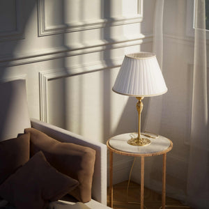 Art Nouveau table lamp Simona collection with decorated brass base featuring floral motifs and pleated ivory white fabric lampshade by Ghidini 1849 - Finish: OBS Bronze Satin Brass