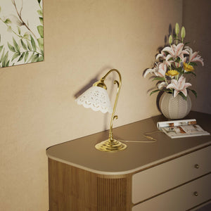 Art Nouveau table lamp with white pierced ceramic shade and decorative curved adjustable brass arm structure by Ghidini 1849 - Finish: OLV Polished Brass