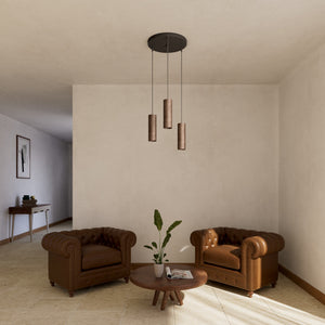 Modern pendant lamp with three brass cylinders and round matte black iron base, height-adjustable pendants, Venere design collection by Ghidini 1849 - Finish: OAS Antique Brass