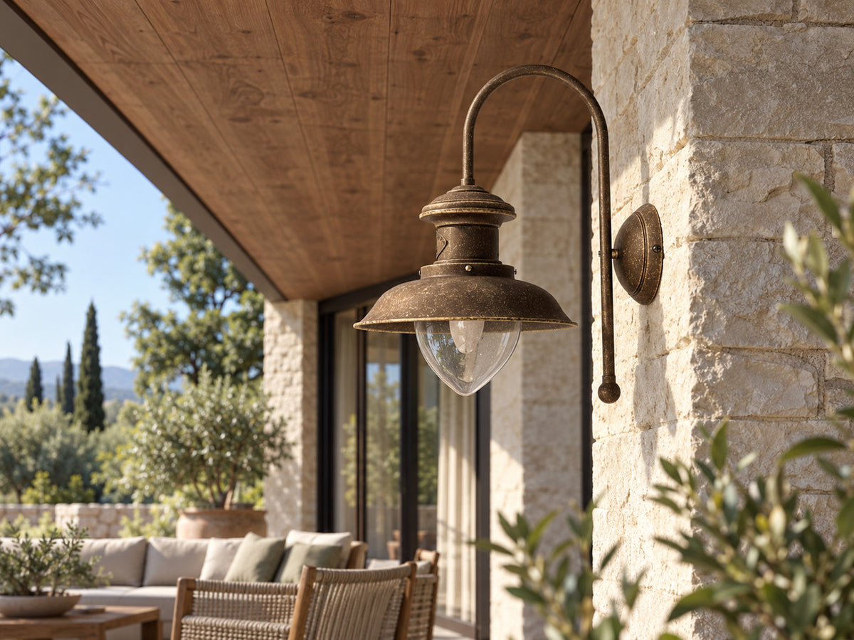 Amalfi brass wall light under the roof of a stone loggia