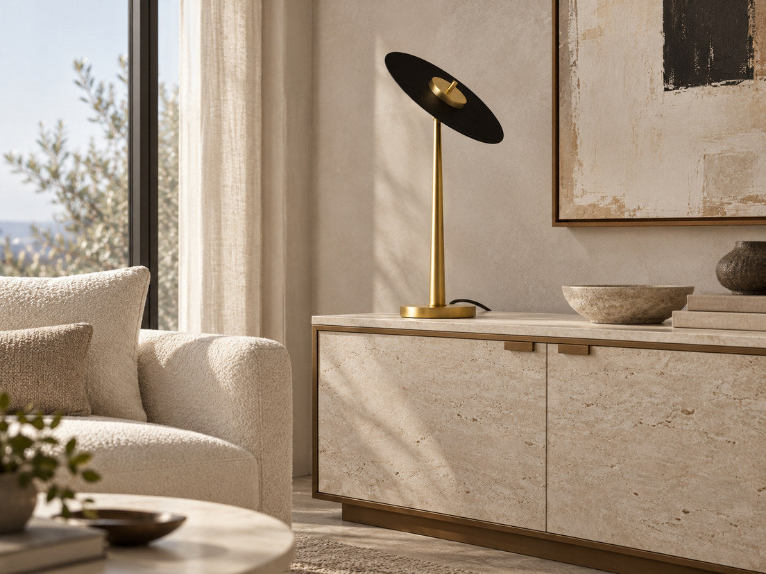 Anima brass table lamp with a black disc on a pale stone cabinet