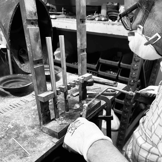An artisan welding a brass component in the Ghidini 1849 factory