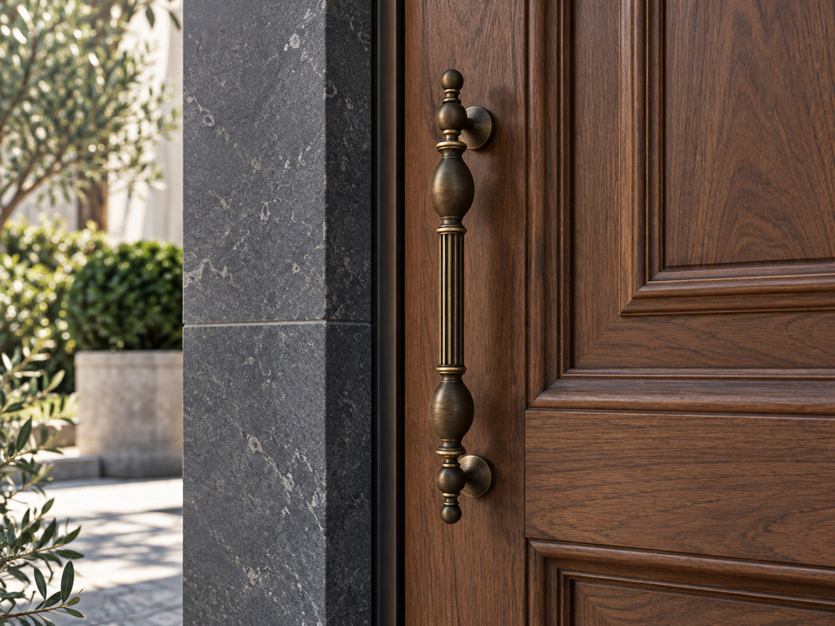Ornate brass door pull in a bronze finish on a walnut entrance door