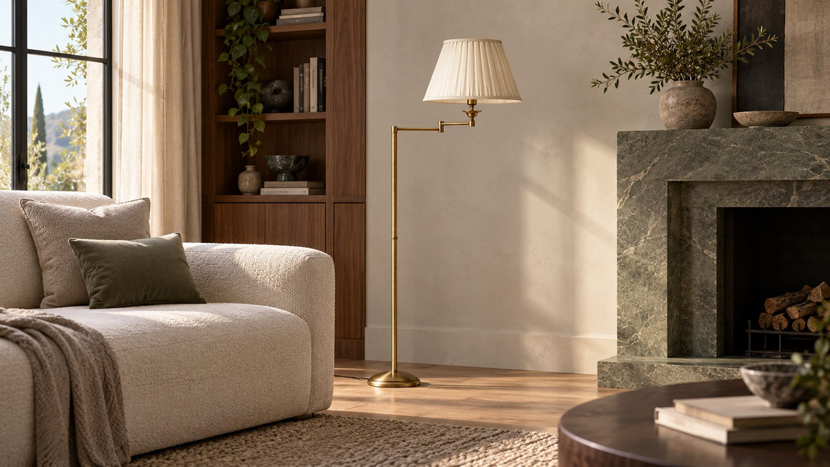 Lampadaire ELEGANT en laiton bronze satiné, abat-jour plissé ivoire, près d’un canapé et d’une cheminée en marbre vert