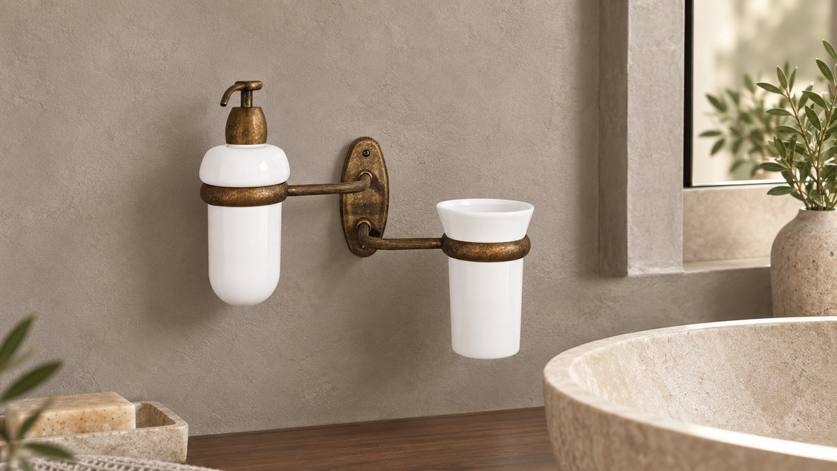 Emma wall set with a soap dispenser and ceramic tumbler on antique brass arms.