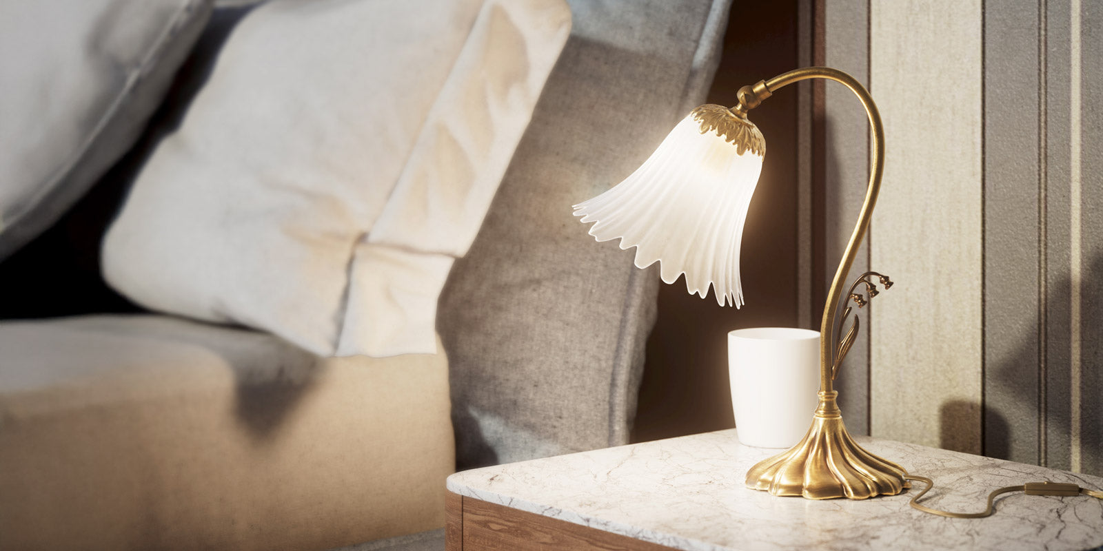 Ghidini 1849 Art Deco and Art Nouveau brass lamps collection cover, featuring an elegant brass table lamp with a sculpted floral glass shade in a sophisticated bedroom setting.