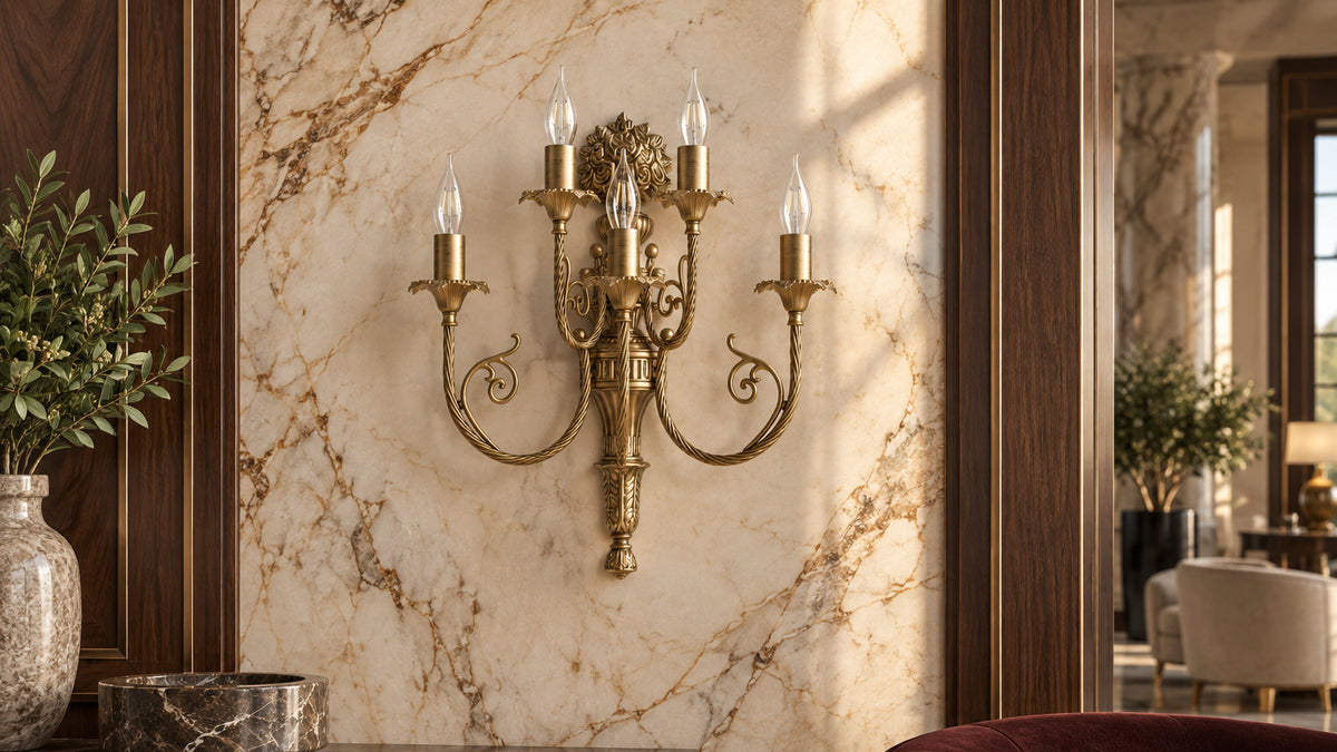 Five-arm bronze brass wall lamp on a marble wall in a luxury hotel lounge