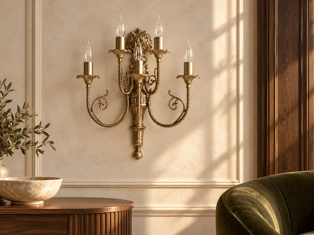 Luigi XV brass wall light with five arms on a pale wall in a furnished salon