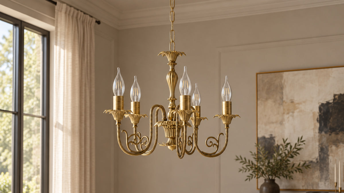 Luigi XV five-arm brass chandelier with clear candle bulbs in a contemporary dining room with tall windows and dark timber furniture.