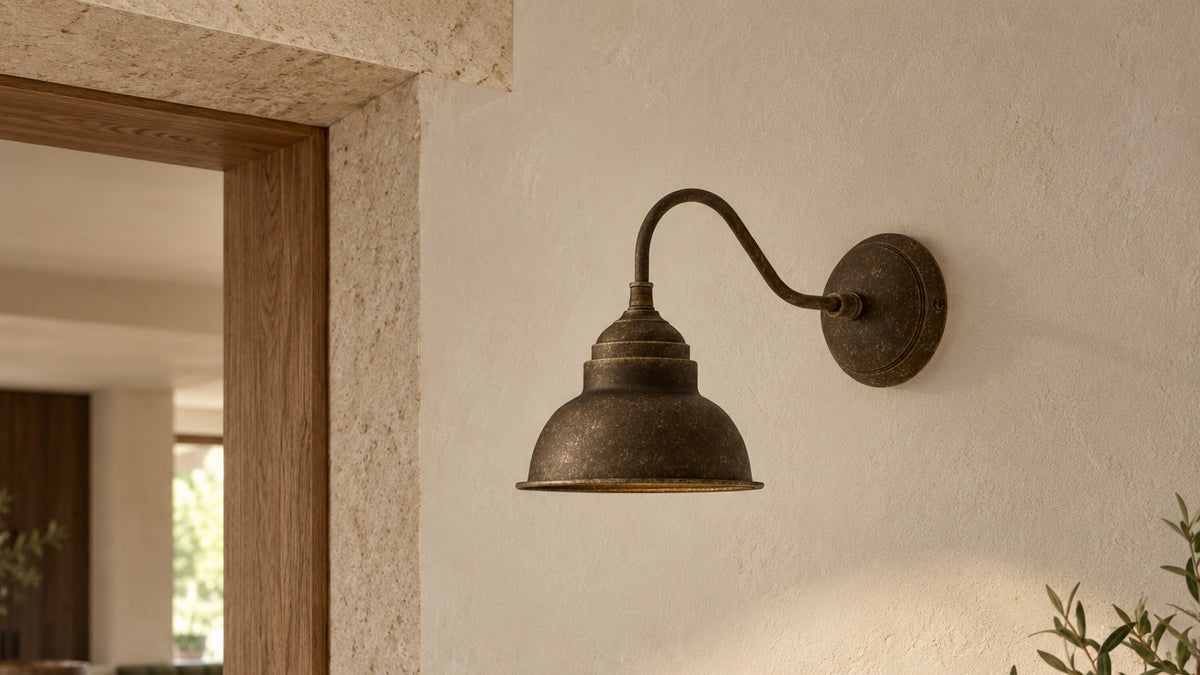 Applique Oslo in ottone anticato accanto all’angolo superiore di un’apertura in pietra e rovere verso la cucina.