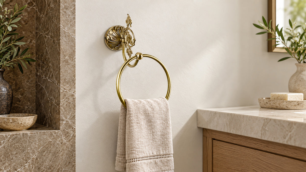 Penelope brass towel ring with leaf decoration and a linen hand towel.