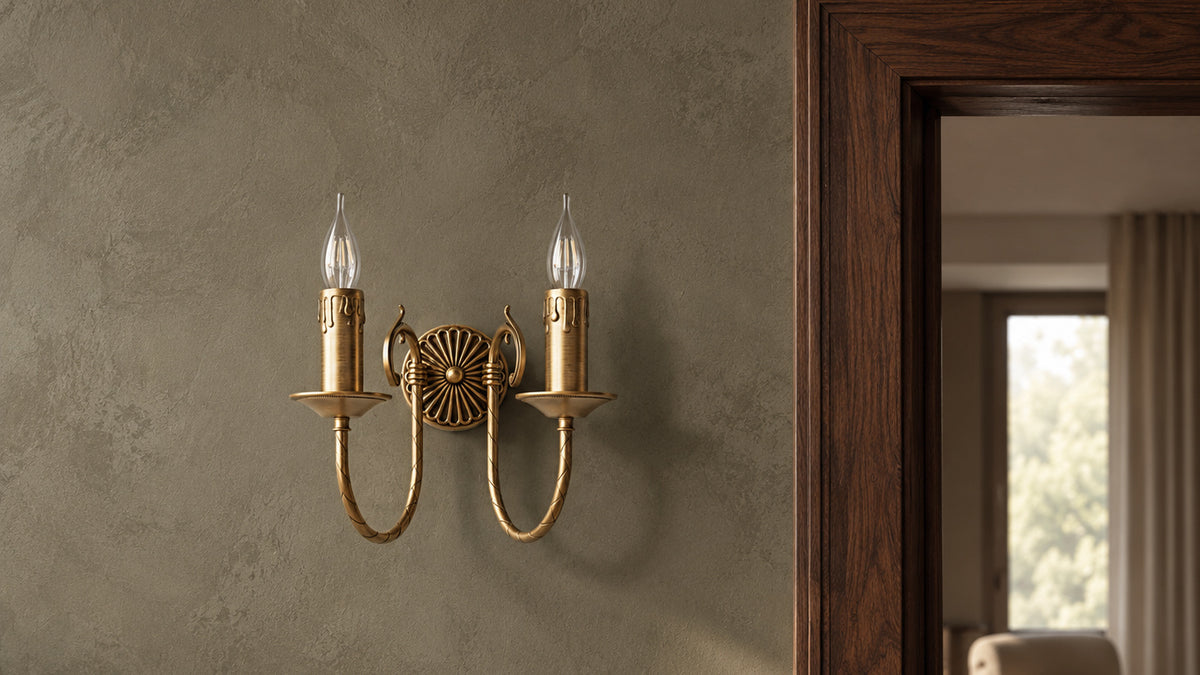 Applique Petalo en laiton à deux lumières près d’une porte en noyer ouvrant sur un salon contemporain.
