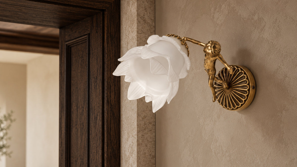 Putti wall lamp with a decorative brass cherub and white flower glass beside an oak and stone doorway.